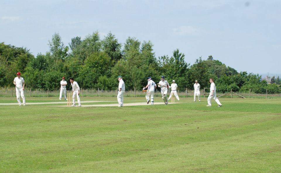 Wide shot of batsmen running during a cricket game.